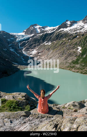 Wanderin mit ausgestreckten Armen suis Triftsee Triftgletscher mit den Schweizer Alpen dans bei Gadmen Banque D'Images