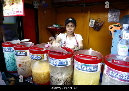 ANTIPOLO CITY, PHILIPPINES - Juillet 3, 2019 : un travailleur à un jus de fruit se prépare une commande pour un client. Banque D'Images