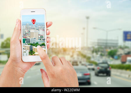 Les mains tenant un téléphone intelligent montrant une partie de l'écran sur la carte navigator sur route, concept de navigation. Banque D'Images