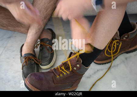 Un couple de mettre sur les chaussures et bottes close up Banque D'Images