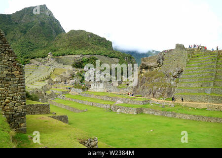 Les visiteurs d'explorer l'intérieur de la Demeure citadelle Inca de Machu Picchu, Cusco, Pérou, Amérique du Sud Banque D'Images