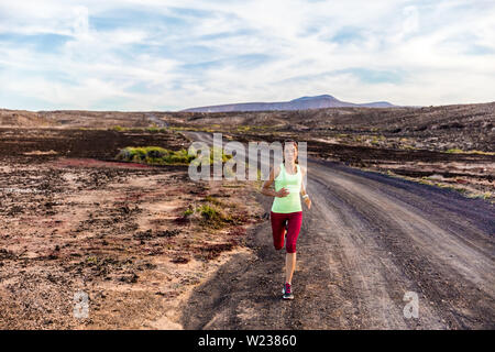 Coureur de l'athlète d'exécution sur les montagnes nature trail. Tous les sports d'entraînement cardio intense formation femme de jogging sur les roches volcaniques incroyable paysage désertique à l'extérieur. La détermination. Banque D'Images