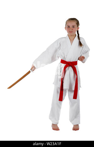 Pre-teen caucasian girl portant un uniforme de karaté kata effectuant une épée en bois avec une épée de formation Banque D'Images