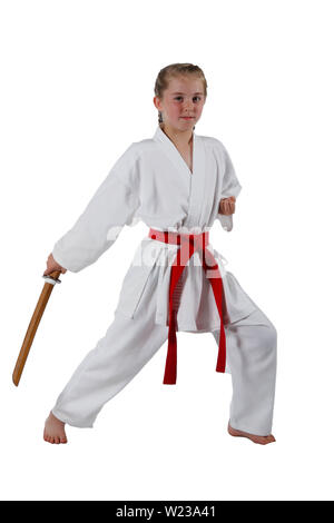 Pre-teen caucasian girl portant un uniforme de karaté kata effectuant une épée en bois avec une épée de formation Banque D'Images