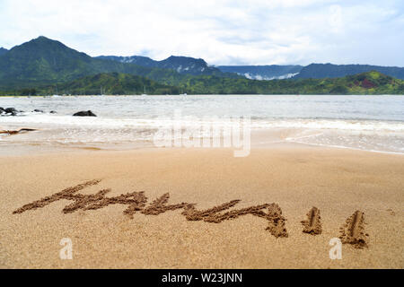 Hawaï mot écrit sur le sable sur la plage hawaïenne. Texte de l'écriture sur fond de texture. Destination célèbre baie d'Hanalei Kauai, États-Unis d'Amérique avec l'océan et les montagnes. Banque D'Images