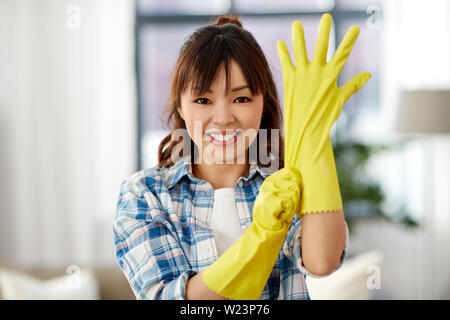 Femme asiatique dans les gants en caoutchouc à la maison de nettoyage Banque D'Images