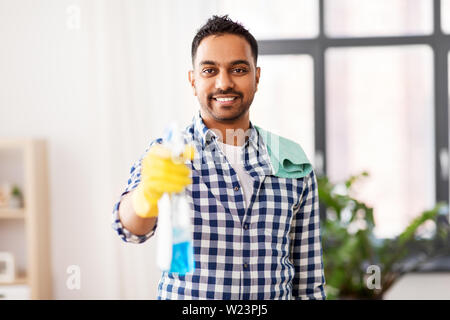 Smiling indian man avec du détergent, le nettoyage à la maison Banque D'Images