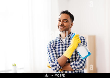 Smiling indian man avec du détergent, le nettoyage à la maison Banque D'Images