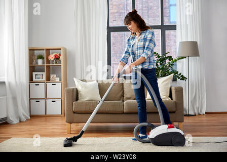 Femme Asiatique avec aspirateur à la maison Banque D'Images