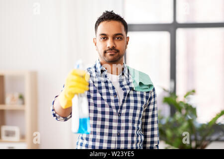 Smiling indian man avec du détergent, le nettoyage à la maison Banque D'Images