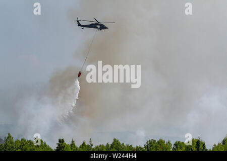 Talkeetna, Alaska. Le 04 juillet, 2019. Une armée de la Garde nationale des États-Unis Alaska hélicoptère Blackhawk UH-60 gouttes d'eau sur un feu de forêt près de Montana Creek 4 juillet 2019 près de Talkeetna, Alaska. Credit : Planetpix/Alamy Live News Banque D'Images