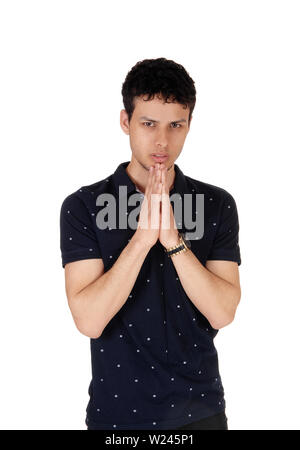 Une image d'un jeune homme beau, debout dans le studio jusqu'à la taille, avec les mains jointes, priant, isolée pour fond blanc Banque D'Images