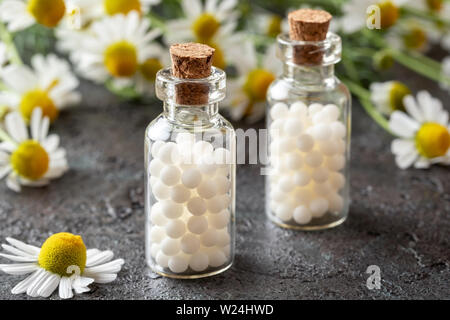 Bouteilles de remèdes homéopathiques avec des fleurs de camomille Banque D'Images