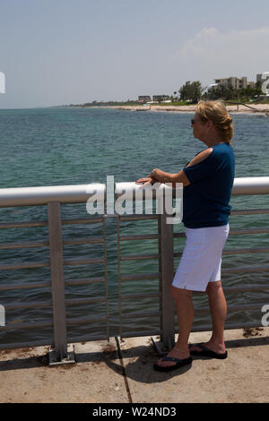 Une femme donne sur le vaste océan Atlantique depuis l'entrée à Ocean Ridge Boca Raton, Floride, USA. Banque D'Images