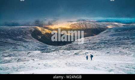 Vue spectaculaire sur la vallée de Glenmalure pendant un court hiver irlandais avec deux randonneurs solitaires dans le lointain - mobile capture. Banque D'Images