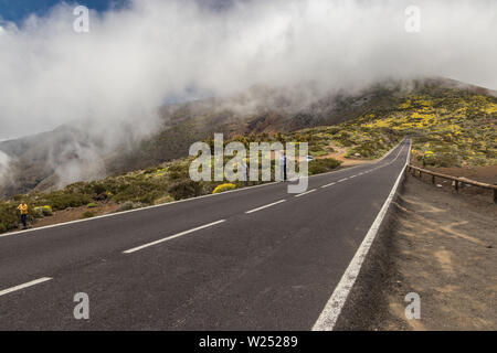 Route moderne, s'étend le long de l'eau de lave et entouré par la végétation de montagne, repose sur les nuages, qui se jettent dans la vallée de la caldera. Nation Banque D'Images