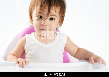 Pretty caucasian baby girl portrait siiting isolé sur la chaise haute Banque D'Images