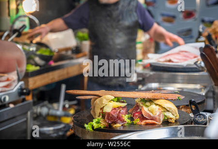 De délicieux sandwiches calories à partir de matières organiques baguettes qui sont farcies au jambon, tomates, fromage, salades et épices cuits sur une assiette, afin que fa Banque D'Images