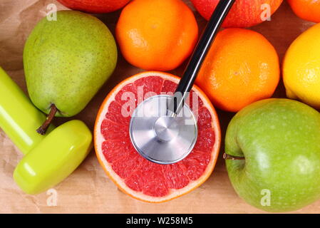 Fruits frais, medical stéthoscope et les haltères pour fitness, concept d'un mode de vie sain et nutrition Banque D'Images