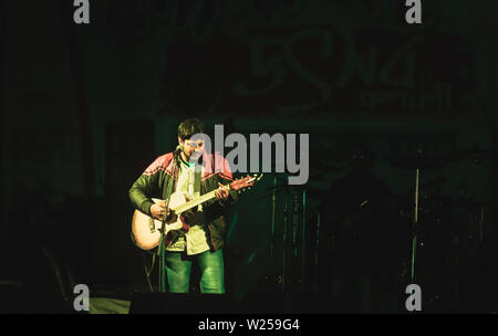 Kolkata Inde 1 Mai 2019 : Le guitariste sur scène. Salle de Concert rock avec bright colorful stage lights et silhouette de fans ou foule j Banque D'Images