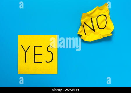 Rappel, combinaison de couleur, choix concept - Close up black inscription manuscrite oui et aucun mot sur deux autocollants carrés jaunes sur blue background Banque D'Images