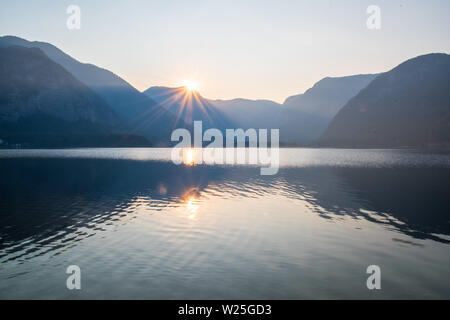 Le lever du soleil sur le lac de Hallstatt, entouré par les Alpes Banque D'Images