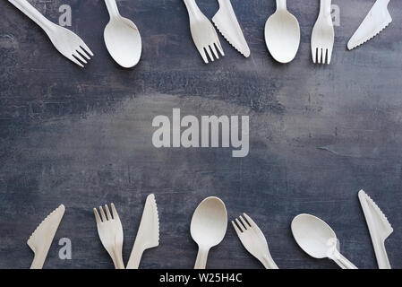 Et naturel de couverts en bois eco - couteaux, cuillères et fourchettes en bas et cadre supérieur, avec copie espace entre. Comptoir de cuisine en marbre noir. Banque D'Images