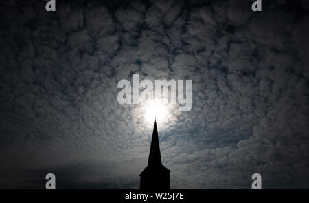 1657, l'Allemagne. Le 06 juillet, 2019. Le clocher de l'église catholique romaine de Saint Johannis photographié dans l'arrière lumière du soleil. Des milliers de fidèles du diocèse de Münster et d'Osnabrück et dans d'autres régions prennent une pause en 1657 sur le pèlerinage à Münster Osnabrück. En 1852, les catholiques pratiquants de Osnabrück fait leur chemin pour la première fois - cette année, la fête du sport fête de la foi a lieu pour la 167e fois. Credit : Friso Gentsch/dpa/Alamy Live News Banque D'Images