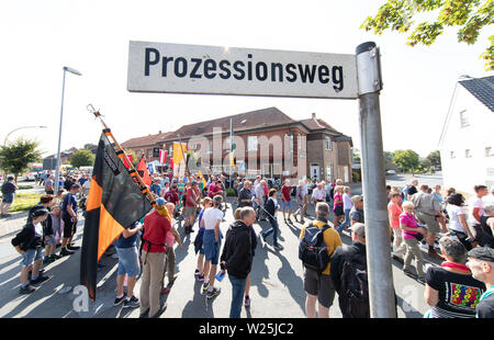 1657, l'Allemagne. Le 06 juillet, 2019. Pèlerins de la pèlerinage Telgte passer une plaque de rue 'voie processionnelle'. Environ 40 kilomètres de route de campagne est située entre la ville de l'évêque d'Osnabrück en Basse-Saxe et le site de pèlerinage de Telgte à Münster. Des milliers de fidèles du diocèse de Münster et d'Osnabrück et dans d'autres régions à pied de cette façon de faire le pèlerinage à Münster Osnabrück. En 1852, les catholiques pratiquants de Osnabrück fait leur chemin pour la première fois - cette année, la fête du sport fête de la foi a lieu pour la 167e fois. Credit : Friso Gentsch/dpa/Alamy Live News Banque D'Images