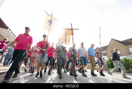 1657, l'Allemagne. Le 06 juillet, 2019. Pèlerins de l'Telgte pèlerinage sur une route. Environ 40 kilomètres de route de campagne est située entre la ville de l'évêque d'Osnabrück en Basse-Saxe et le site de pèlerinage de Telgte à Münster. Des milliers de fidèles du diocèse de Münster et d'Osnabrück et dans d'autres régions à pied de cette façon de faire le pèlerinage à Münster Osnabrück. En 1852, les catholiques pratiquants de Osnabrück fait leur chemin pour la première fois - cette année, la fête du sport fête de la foi a lieu pour la 167e fois. Credit : Friso Gentsch/dpa/Alamy Live News Banque D'Images