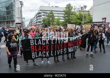 Berlin, Allemagne. 05 juillet, 2019. Les manifestants tenir une bannière avec l'inscription 'Black vit" à l'ancien Checkpoint Charlie lors d'une marche de protestation contre le racisme sous la devise 'Black vit". L'une des raisons de la démo a été la découverte du corps de Rita Awour Ojunge, un demandeur d'asile en provenance du Kenya qui avait disparu depuis le 7 avril 2019, dans le Brandebourg, à la mi-juin. Les manifestants ont exigé une explication de l'affaire sous le hashtag # SayHerName. Credit : Stefan Jaitner/dpa/Alamy Live News Banque D'Images
