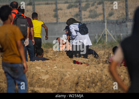 5 juillet 2019 - Gaza, Palestine. 05 juillet 2019. Des manifestants palestiniens en conflit avec les forces israéliennes au cours de ce vendredi est une grande marche du retour dans la région de Malika sur l'est de la ville de Gaza. Des milliers de Palestiniens avait convergé sur différents sites à proximité de la frontière Gaza-Israel à rejoindre les manifestations. Certains des manifestants ont lancé des pierres vers les soldats israéliens stationnés sur l'autre côté de la clôture qui ont répondu avec des gaz lacrymogènes et des balles réelles blessant des dizaines de manifestants palestiniens. Des manifestants palestiniens ont organisé une grande marche du retour manifestations depuis le 30 mars l'année dernière Banque D'Images