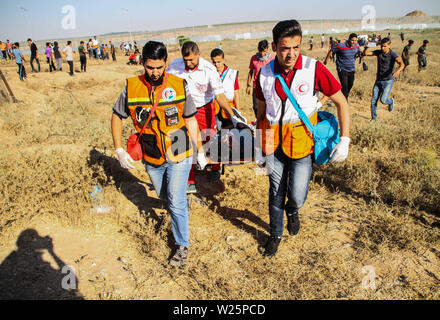 5 juillet 2019 - Gaza, Palestine. 05 juillet 2019. Des manifestants palestiniens en conflit avec les forces israéliennes au cours de ce vendredi est une grande marche du retour dans la région de Malika sur l'est de la ville de Gaza. Des milliers de Palestiniens avait convergé sur différents sites à proximité de la frontière Gaza-Israel à rejoindre les manifestations. Certains des manifestants ont lancé des pierres vers les soldats israéliens stationnés sur l'autre côté de la clôture qui ont répondu avec des gaz lacrymogènes et des balles réelles blessant des dizaines de manifestants palestiniens. Des manifestants palestiniens ont organisé une grande marche du retour manifestations depuis le 30 mars l'année dernière Banque D'Images