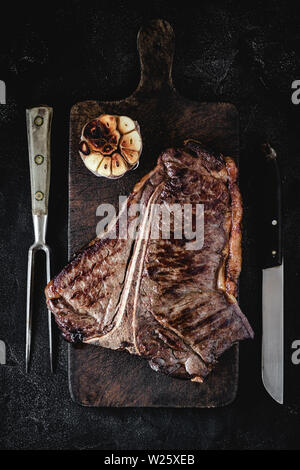 Sèche Haut grillé de T-bone steak sur Planche rustique foncé. Boeuf USDA. Banque D'Images