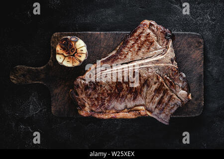 Sèche Haut grillé de T-bone steak sur Planche rustique foncé. Boeuf USDA. Banque D'Images