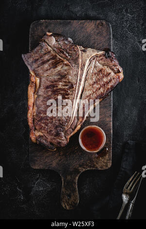 Sèche Haut grillé de T-bone steak sur Planche rustique foncé. Boeuf USDA. Banque D'Images