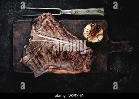 Sèche Haut grillé de T-bone steak sur Planche rustique foncé. Boeuf USDA. Banque D'Images