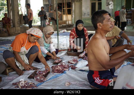 Trancher la viande de chèvre musulmane lorsque l'Eid Al Adha de Semarang, Indonésie Banque D'Images