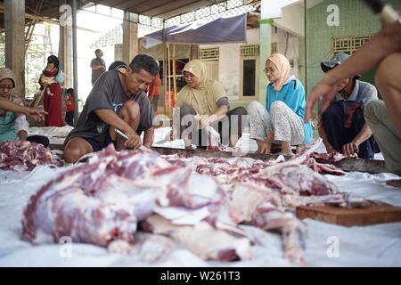 Trancher la viande de chèvre musulmane lorsque l'Eid Al Adha de Semarang, Indonésie Banque D'Images