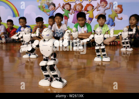 La Chine. 6 juillet, 2019. (190706) -- 6 juillet, BINZHOU, 2019 (Xinhua) -- les élèves du primaire regarder danser les robots lors d'une manifestation scientifique dans le comté de Binzhou City, province de Shandong en Chine orientale, le 6 juillet 2019. (Photo de Chen Bin/Xinhua) Credit : Xinhua/Alamy Live News Banque D'Images