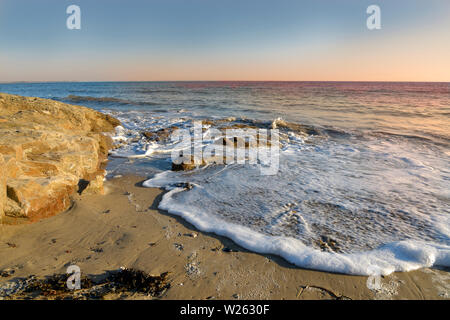 Côte au coucher et la mousse de la vague sur une plage de Damgan, une commune française, située dans le département de la Bretagne, dans le nord-ouest de la France. Banque D'Images