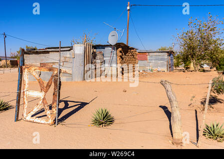 Accueil faits de tôle ondulée, avec une grande antenne satellite, dans une ville située à la périphérie d'Otjiwarongo, Namibie Banque D'Images