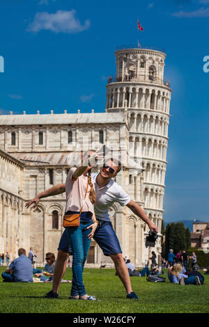 Pise, Italie - Avril 2018 : jeune couple de touristes de prendre un en selfies avant de la célèbre tour penchée de Pise Banque D'Images