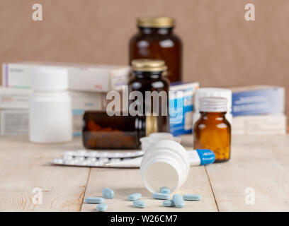 Un groupe de boîtes de médicaments, pilules, thermomètre et blisters de comprimés sur la table en bois Banque D'Images