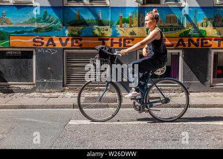 Un cycliste au Danemark a passé les cycles de la planète 'Enregistrer' sign Banque D'Images