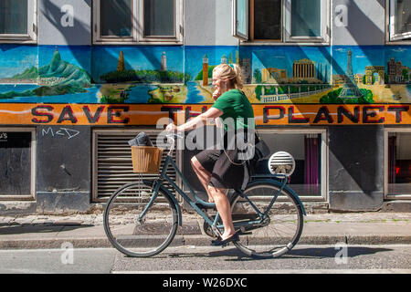 Un cycliste au Danemark a passé les cycles de la planète 'Enregistrer' sign Banque D'Images