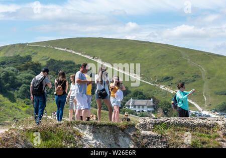 La Côte Jurassique, Lulworth, Dorset, UK. 6 juillet 2019. Des milliers de touristes font leur chemin à la plage de Lulworth Cove et Durdle Door sur la côte jurassique du Dorset. La côte a subi l'érosion de l'énorme nombre de personnes marchant sur la falaises crayeuses. Crédit : Thomas Faull/Alamy Live News Banque D'Images