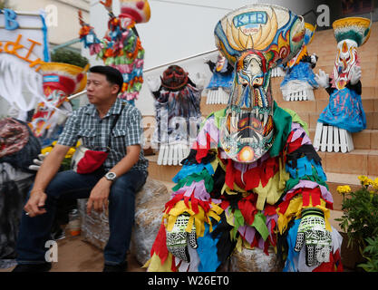 Un homme assis à un Thaï habillé dans un costume avec un masque lors d'un festival à Loei.Le Phi Ta Khon festival est le plus grand attrait pour le village agricole de sleepy autrement Dan Sai, niché dans les montagnes de la province du nord-est de la Thaïlande. L'événement est propre à Dan Sai, mais est-ce que la moissonneuse-batteuse d'éléments d'autres Isaan festivals, comme la fusée de festivals apportent la pluie. Banque D'Images