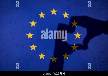 Mains faire un cœur ombre sur grunge drapeau de l'Union européenne l'Union européenne sur fond de mur de béton texturé Banque D'Images