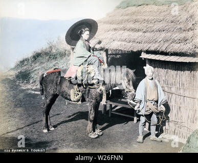 [ 1890 - Japon femme japonaise sur l ] - un voyageur femme tenant un parasol monte un cheval assez triste à la tenue par un agriculteur. Le bâtiment de chaume semble être un lieu de repos. 19e siècle vintage albumen photo. Banque D'Images